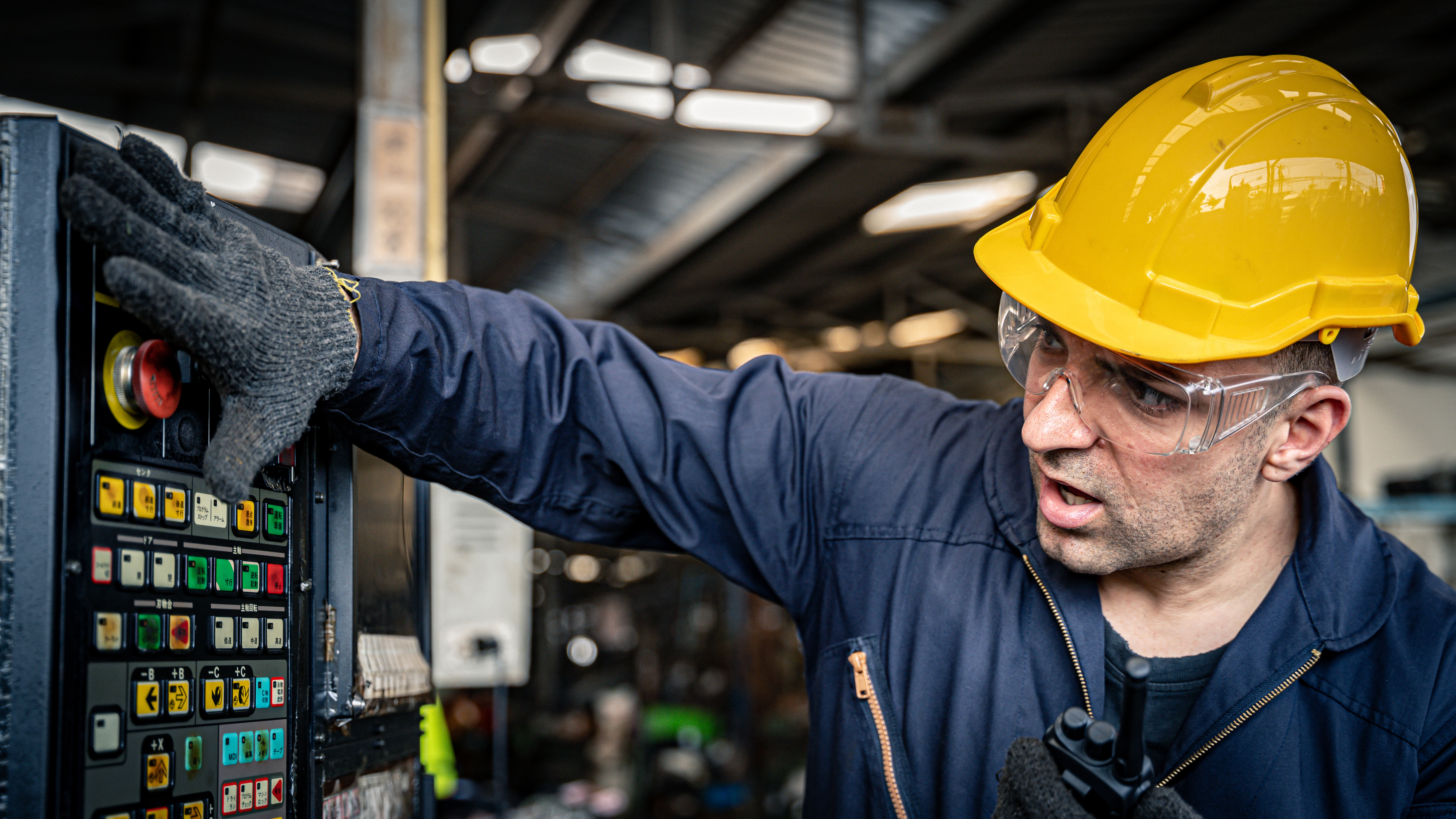 Factory worker pushing red button to emergency turn off the machine.